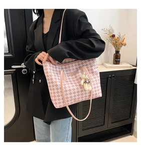 Borsa tote a scacchi rosa e bianca con ciondolo a forma di orso e vestito casual modella