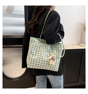 Borsa tote a scacchi verde e bianca con ciondolo a forma di orso leopardato sulla spalla