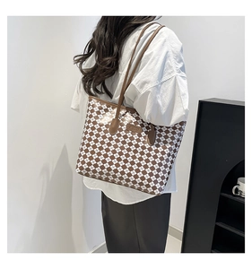 Borsa tote a scacchi marrone e bianca portata a spalla da una modella in stile minimalista