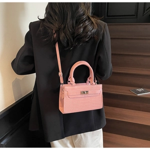 Detail of pink crocodile embossed leather texture with classic metal twist lock buckle