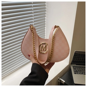 Detailed view of pink moon bag featuring a gold M logo and chunky metallic chain strap