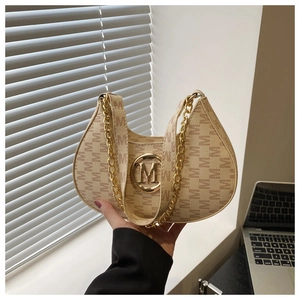 Close-up of beige moon bag with monogram pattern and gold M-logo buckle detail