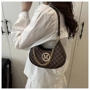 Close-up of brown monogram crescent bag with golden M logo and chain decoration