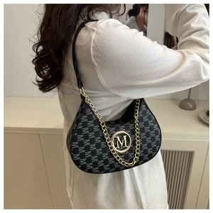 Detail of black crescent shoulder bag with jacquard M pattern and gold metal M hardware