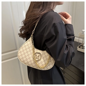 Detail of vintage monogram underarm bag with gold metal M logo and chain strap