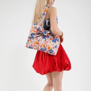 Floral print cotton tote bag with a large bow design worn by a model in studio