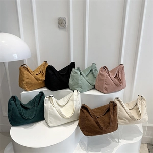 Grandi borse tote in velluto a coste in vari colori in un ambiente minimalista