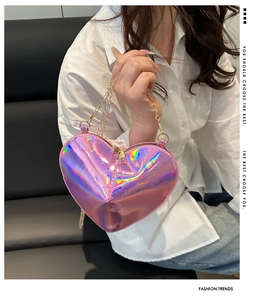 Close-up of pink holographic heart-shaped mini bag featuring gold metal chain and zipper