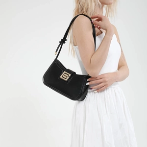 Minimalist black shoulder bag with gold geometric buckle and knotted strap detail