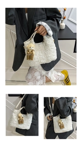 Close-up of white bubble textured handbag with a cute teddy bear charm accessory