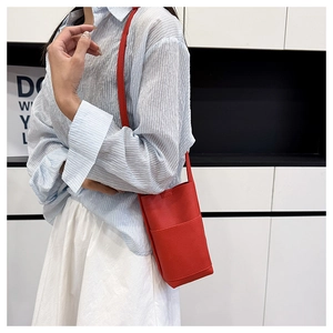 Detail einer roten Handytasche mit Lychee-Muster als Umhängetasche zum Freizeitoutfit