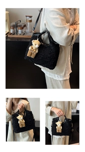 Close-up of black bubble textured crossbody bag with a cute yellow plush bear charm