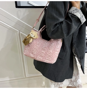 Gros plan du sac en tissu bulle rose avec pendentif ours et texture plissée