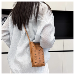 Detail of a brown faux leather crossbody phone bag featuring a cute bear and diamond pattern