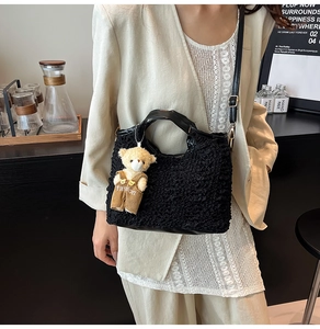 Détail du sac cabas plissé noir avec breloque ours mignon dans un décor minimaliste