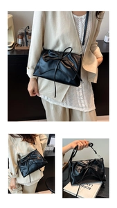 Macro detail of casual black tote bag featuring a decorative bow and silver metal hardware