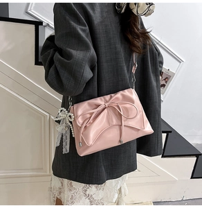 Détail du sac à bandoulière rose avec nœud, cuir PU souple et breloque en dentelle