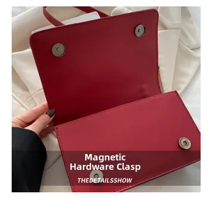 Detail of red leather flap bag showing silver magnetic snap button closures and stitching