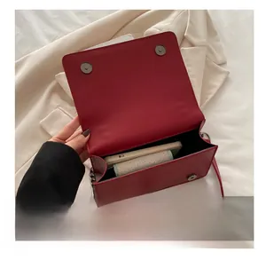 Detail view of red leather crossbody bag showing interior capacity and magnetic closure