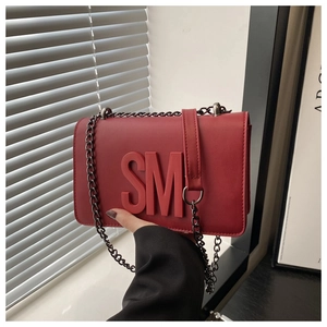 Detailed shot of red leather crossbody bag with SM logo and metallic chain strap