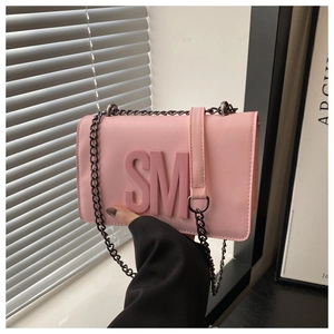 Detail of pink small square bag with 3D SM letter logo and dark metal chain strap
