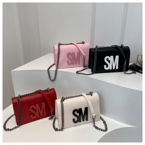 Detail showing high-quality synthetic leather square bags in four colors with metal chains