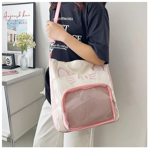 Détail des oreilles de chat et poche en filet rose sur le sac cabas en toile