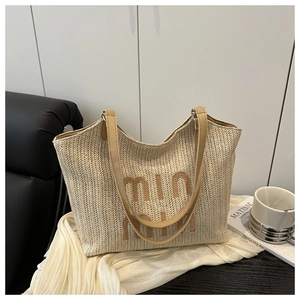 Macro shot of woven beach tote texture with chic leather handles and logo detail