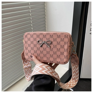 Close-up of pink crossbody bag with M-pattern print and stylish wide woven strap
