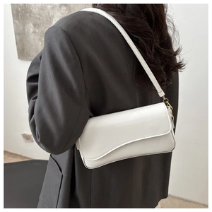 Detailed back view of a minimalist white leather baguette bag with gold metal accents