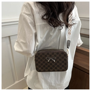 Detail of vintage flap bag featuring M-pattern print and woven ethnic style wide strap