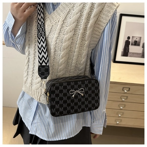 Detail of vintage square crossbody bag with M-pattern print and wide geometric strap