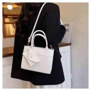 White leather handbag with detachable strap and mini coin purse shown on model