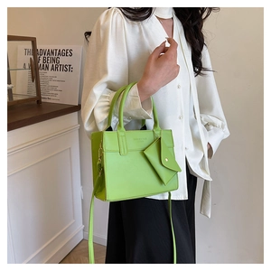 Detailed macro view of vibrant lime green tote bag featuring a detachable mini envelope pouch