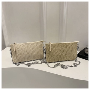Dettaglio di borse in paglia intrecciata beige e kaki con perline argentate e tracolla a catena