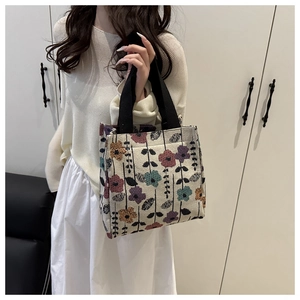 Detail of vintage floral jacquard fabric and black woven handles on this tote bag