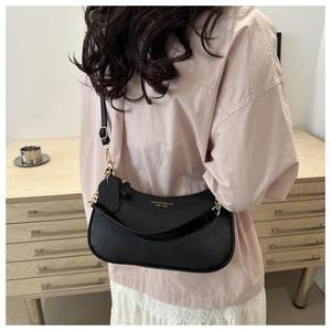 Detail of black pebbled leather crescent bag with golden chain and fashion logo