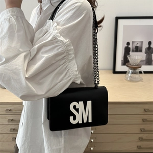 Minimalist black matte crossbody bag with white SM letters and gunmetal chain strap