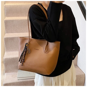 Λεπτομέρεια vintage καφέ τσάντα tote με υφή δέρματος και γούρι τένις