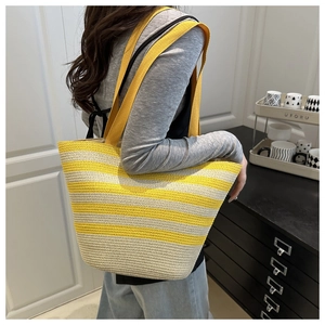 Détail macro du sac cabas en raphia tissé avec rayures jaunes et blanches et texture