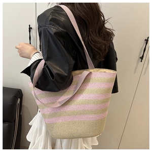 Détail du sac cabas en paille rayé rose et beige montrant la texture tressée