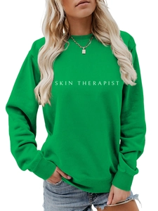 Détail de l'impression blanche Skin Therapist sur un sweatshirt vert à col rond