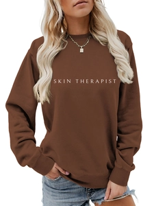 Détail de l'imprimé SKIN THERAPIST sur le sweat à col rond marron foncé décontracté