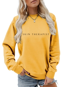 Détail d'un sweat-shirt à col rond jaune ample avec imprimé Skin Therapist