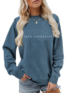 Détail des poignets côtelés et de l'imprimé SKIN THERAPIST sur le sweat-shirt bleu