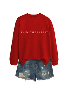 Vue détaillée du sweat en coton rouge avec imprimé blanc SKIN THERAPIST au centre