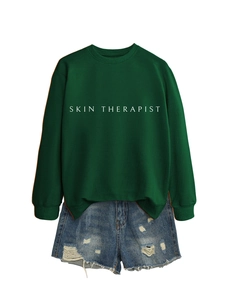Gros plan sur l'imprimé Skin Therapist du sweat-shirt vert et short en jean usé