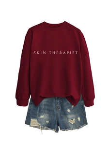 Détail d'un sweat bordeaux Skin Therapist assorti à un short en jean bleu délavé