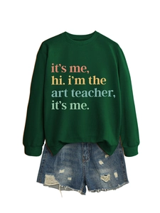 Flat lay of a green 'I'm the art teacher' sweatshirt paired with distressed denim shorts