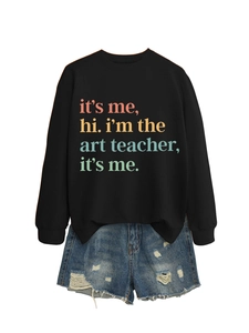 Close-up of black crewneck sweatshirt with colorful text print and ripped denim shorts